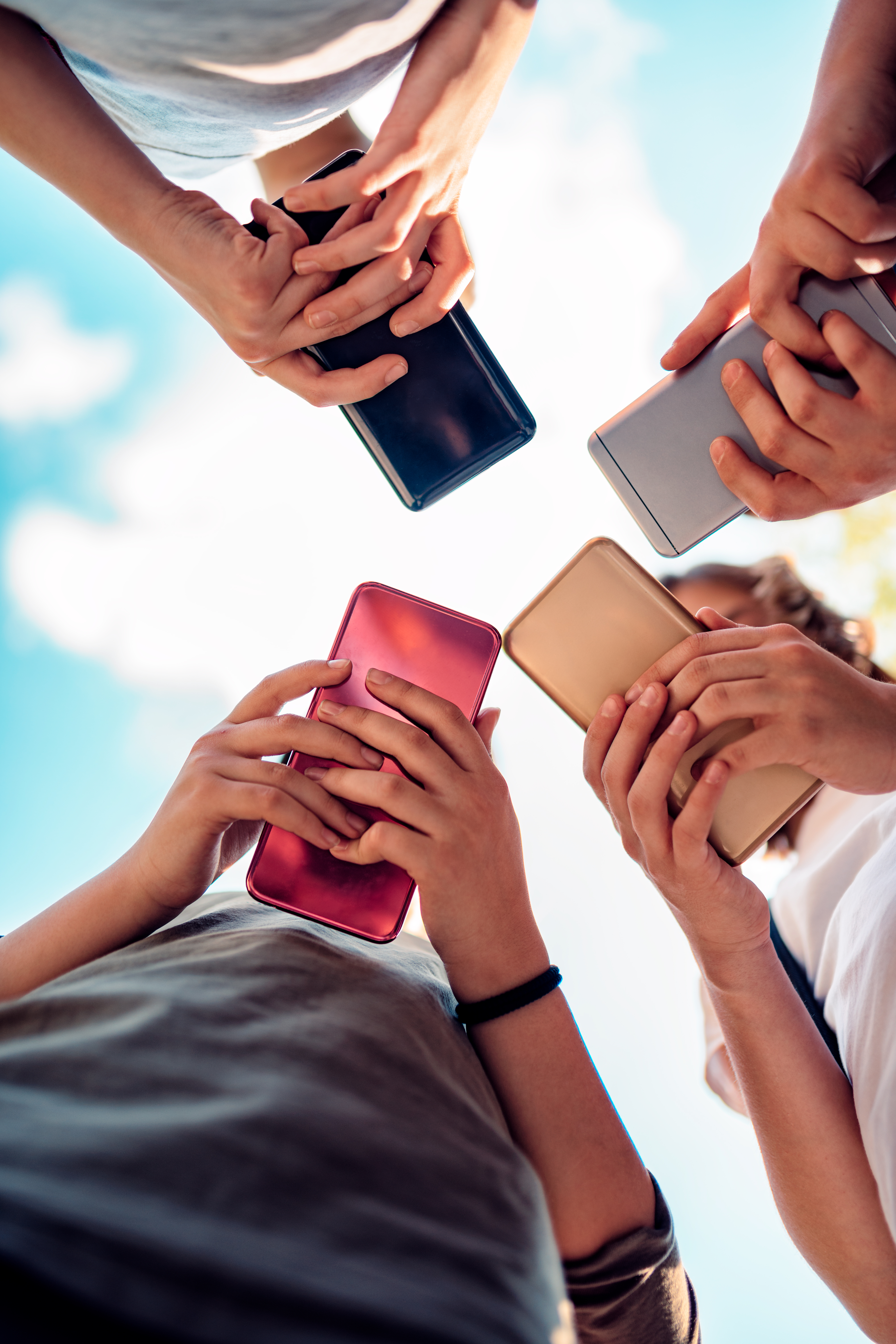 Gruppe med ungdommer som ser på telefonene sine